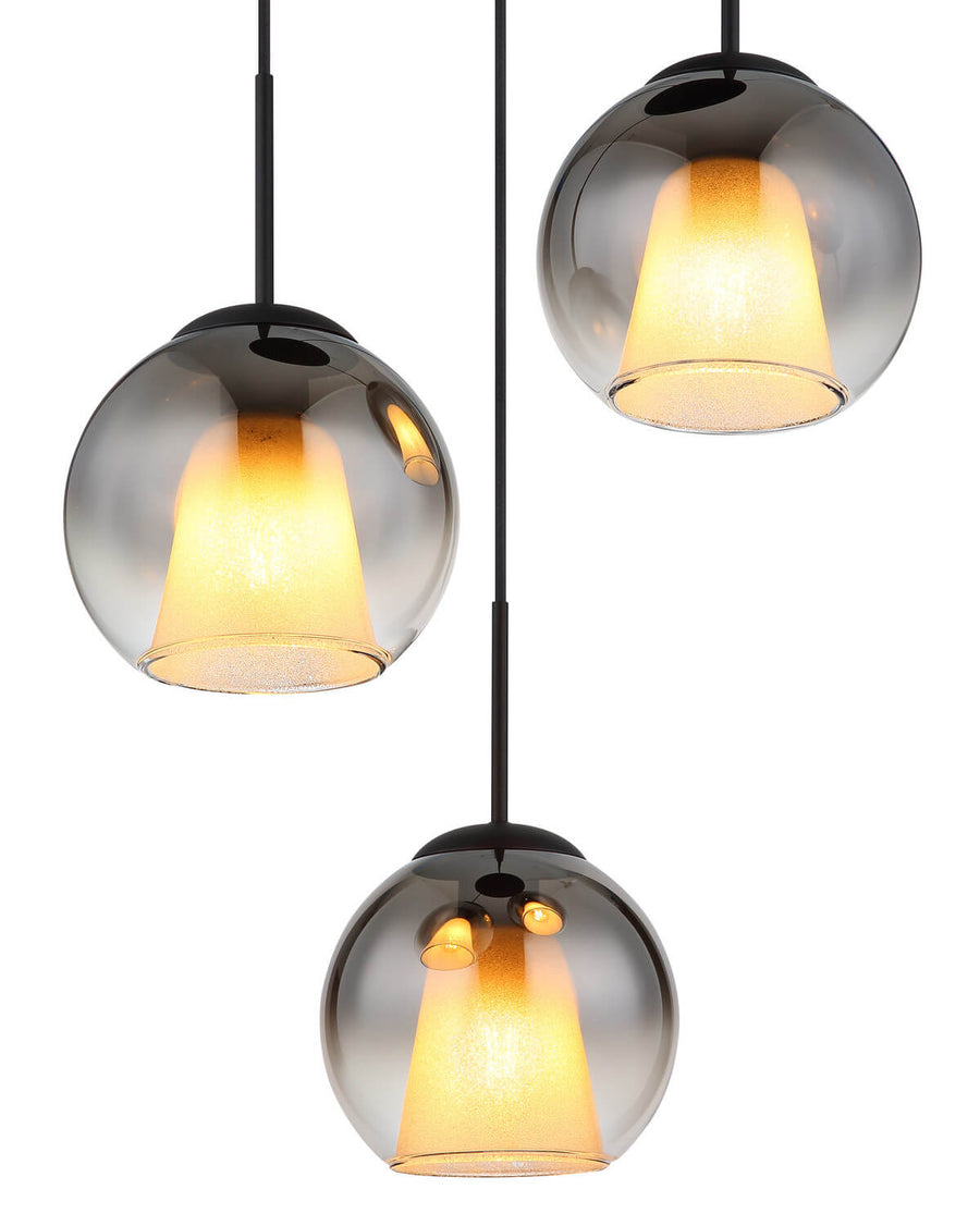 Gros plan sur les trois globes en verre fumé avec diffuseurs coniques jaunes allumés.