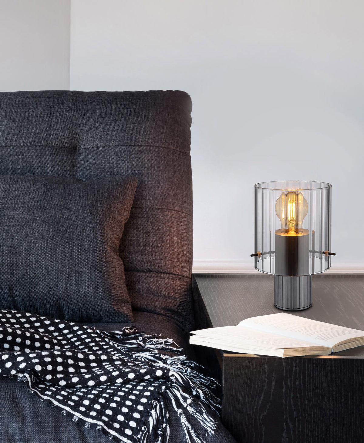 Mise en ambiance : lampe posée sur une table de chevet près d'un livre