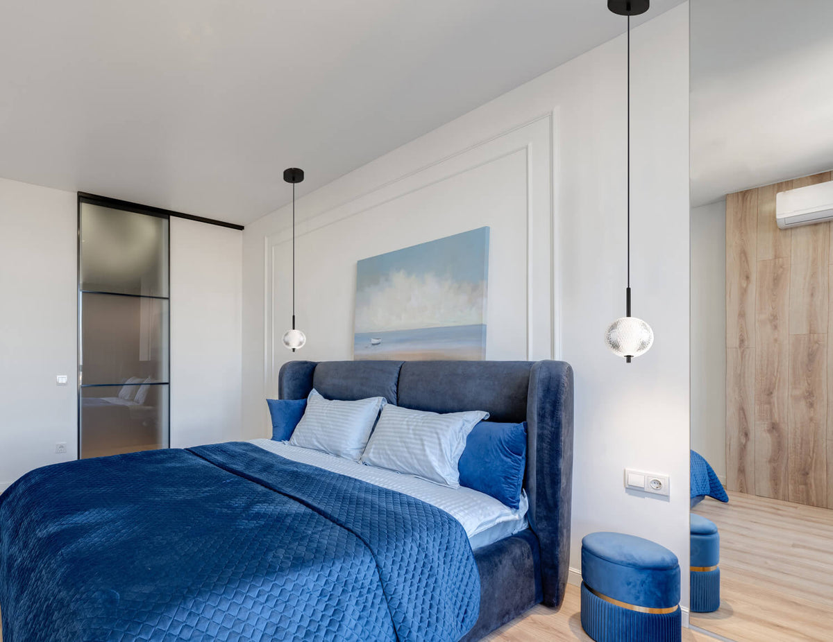 Mise en ambiance : deux suspensions éclairées au-dessus des chevets d'une chambre moderne