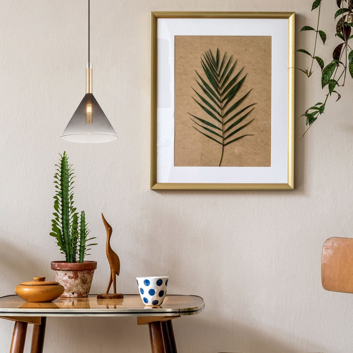 Mise en ambiance au-dessus d'une table en verre avec cadre et plante