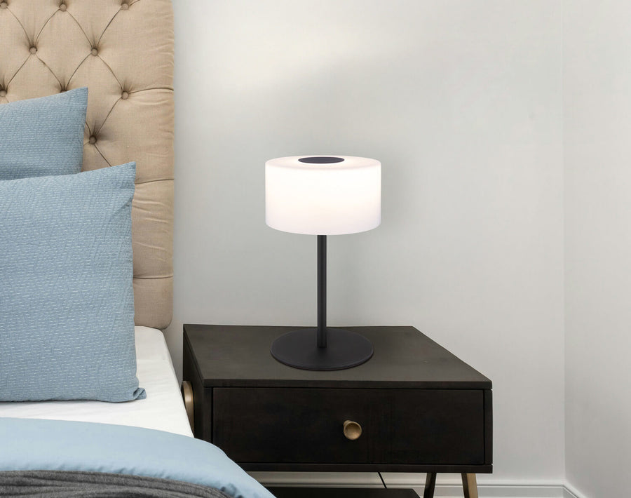 Mise en situation sur table de chevet en bois, lampe allumée dans une chambre
