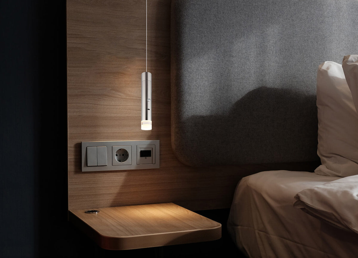 Mise en ambiance du luminaire suspendu au-dessus d'une table de chevet en bois
