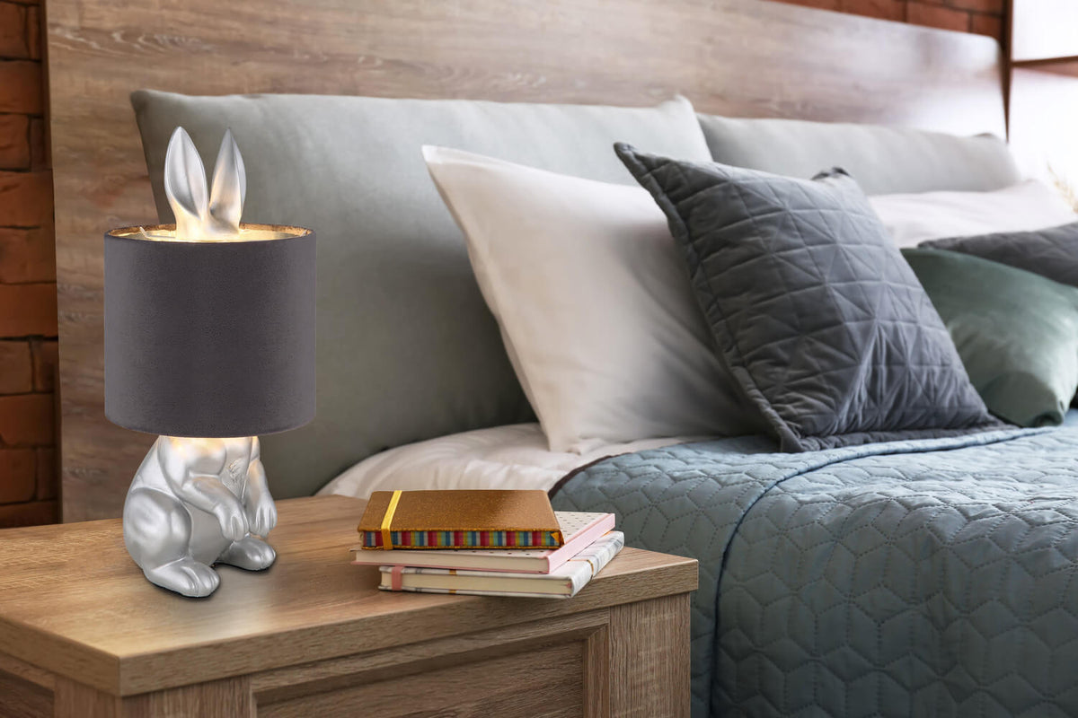 Lampe lapin posée sur une table de nuit en bois dans une chambre à coucher