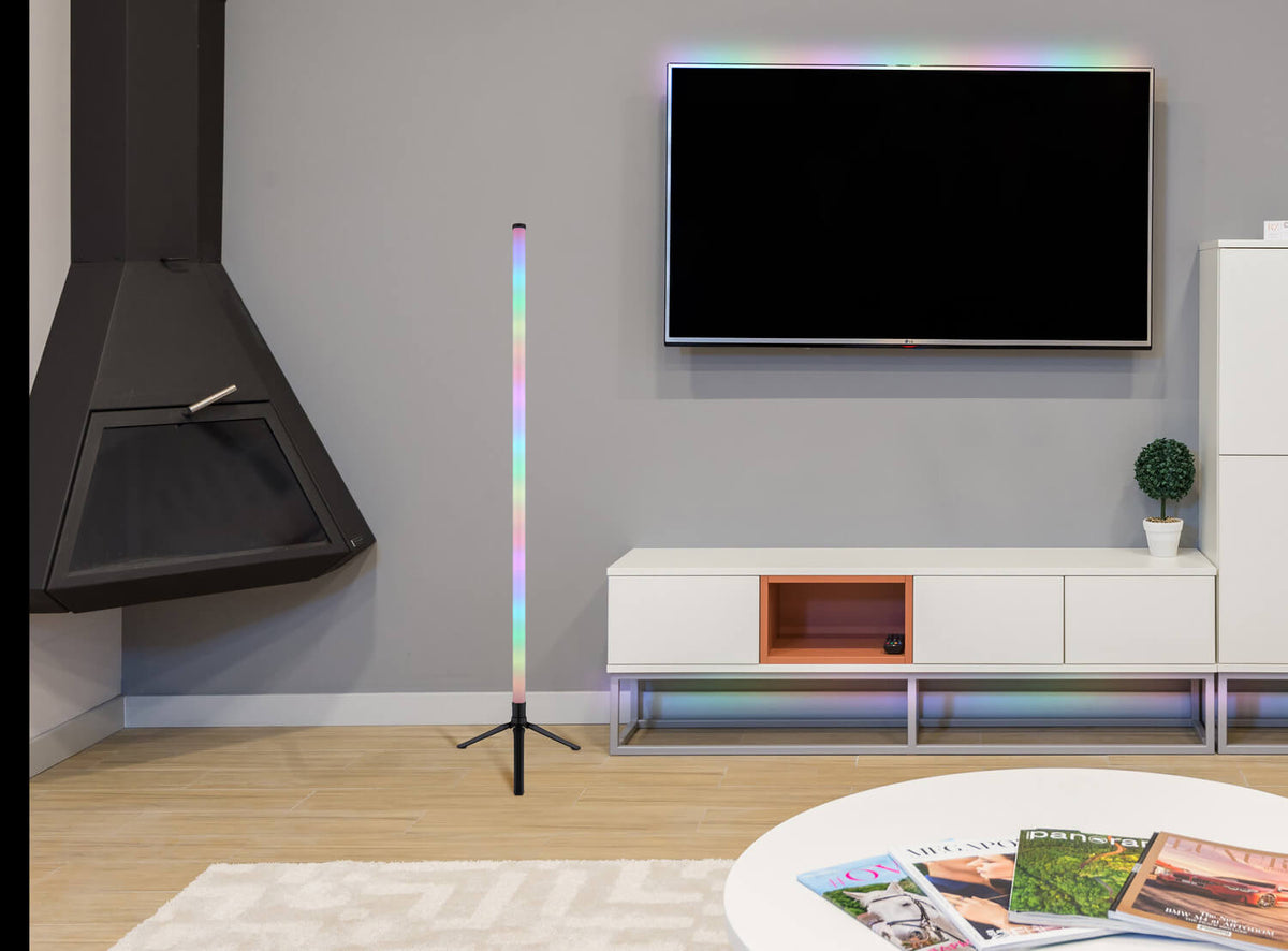 Mise en ambiance salon, lumière arc-en-ciel devant meuble TV et mur gris