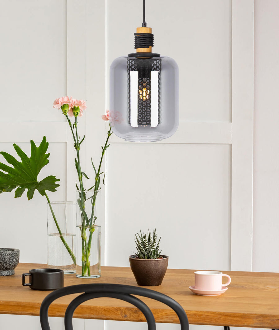 Scène d'intérieur avec la suspension au-dessus d'une table en bois, vases et fleurs