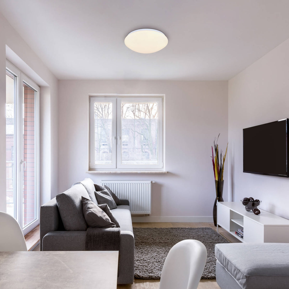 Mise en ambiance du plafonnier allumé au plafond d'un salon moderne gris