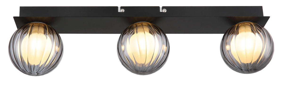 Vue de face du plafonnier allumé avec ses trois globes en verre strié.