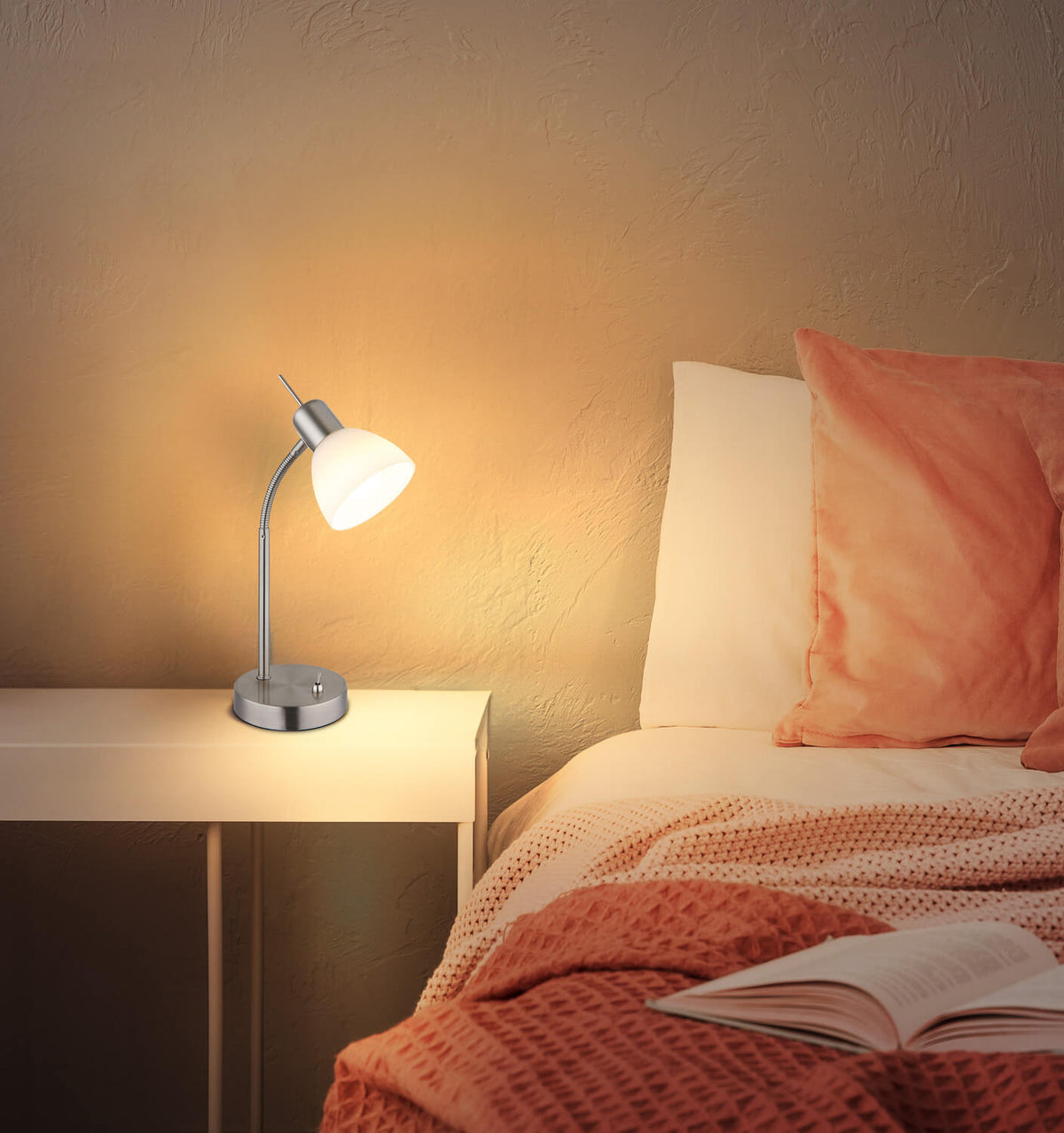 mise en ambiance, lampe allumée posée sur une table de chevet dans une chambre