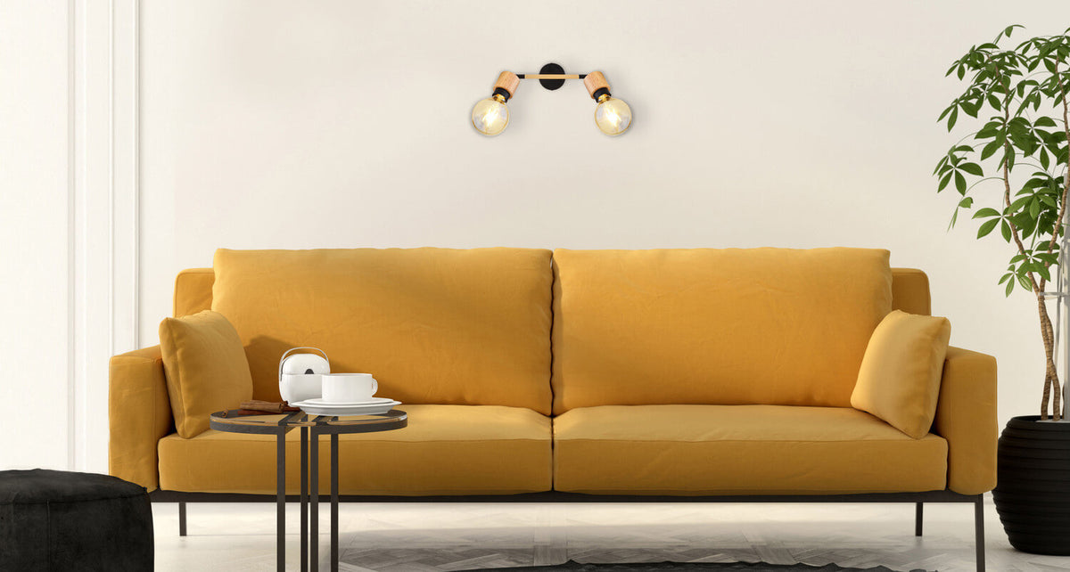 Mise en ambiance murale au-dessus d'un canapé jaune moutarde dans un salon
