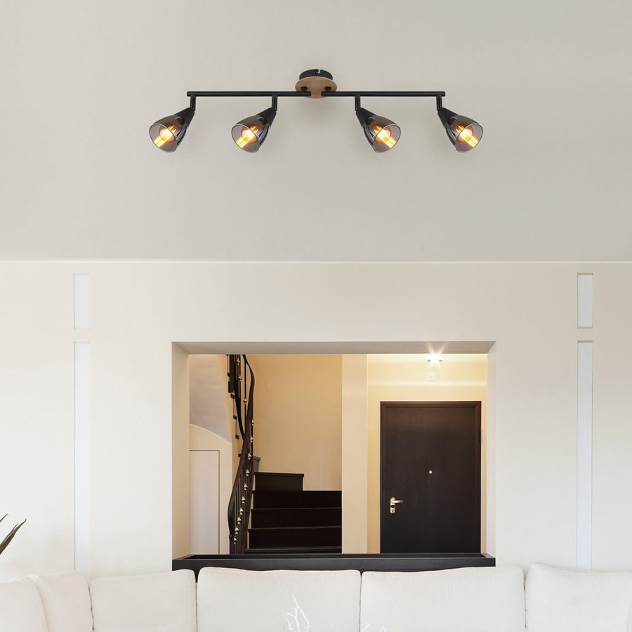 Spot fixé au plafond blanc au-dessus d'une ouverture vers escalier sombre