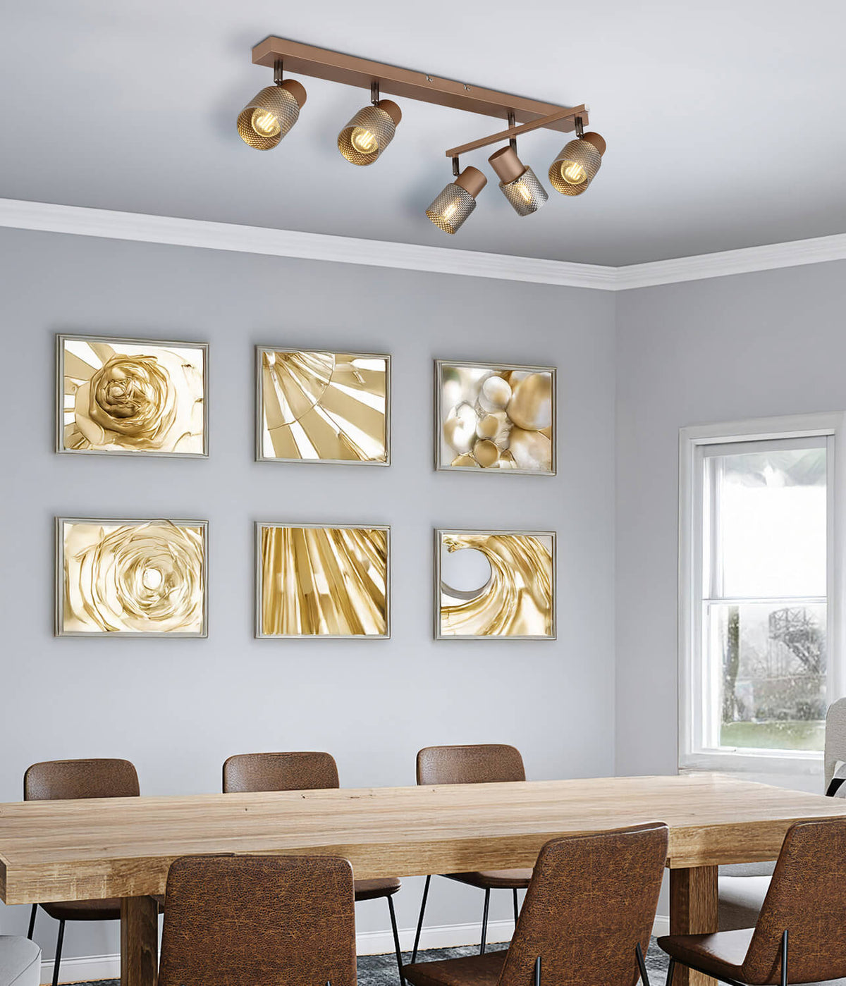 Spot plafond installé au-dessus d'une table de salle à manger, cadres dorés au mur