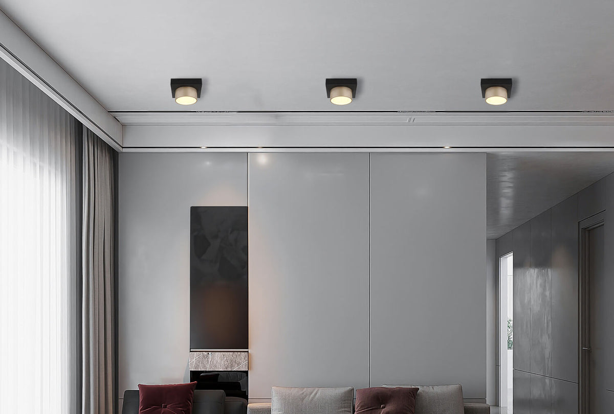 Mise en ambiance de trois plafonniers noirs alignés au plafond