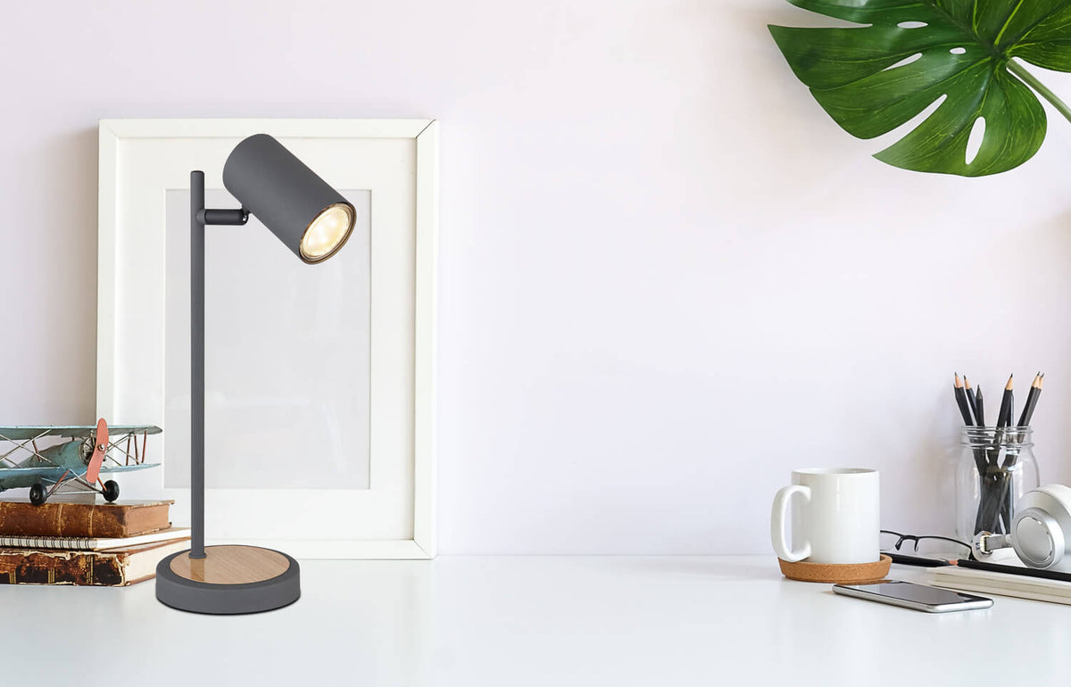 Mise en ambiance sur un bureau blanc avec cadre, plante et accessoires de travail.