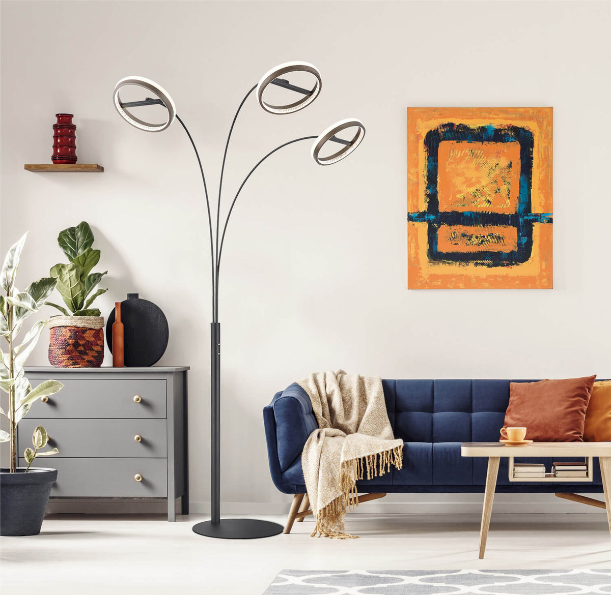 Mise en ambiance du lampadaire allumé dans un salon bleu avec fauteuil et tableau
