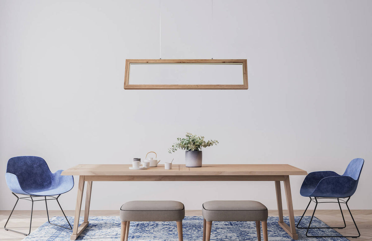 Mise en ambiance : suspension rectangulaire au-dessus d'une table à manger en bois clair.