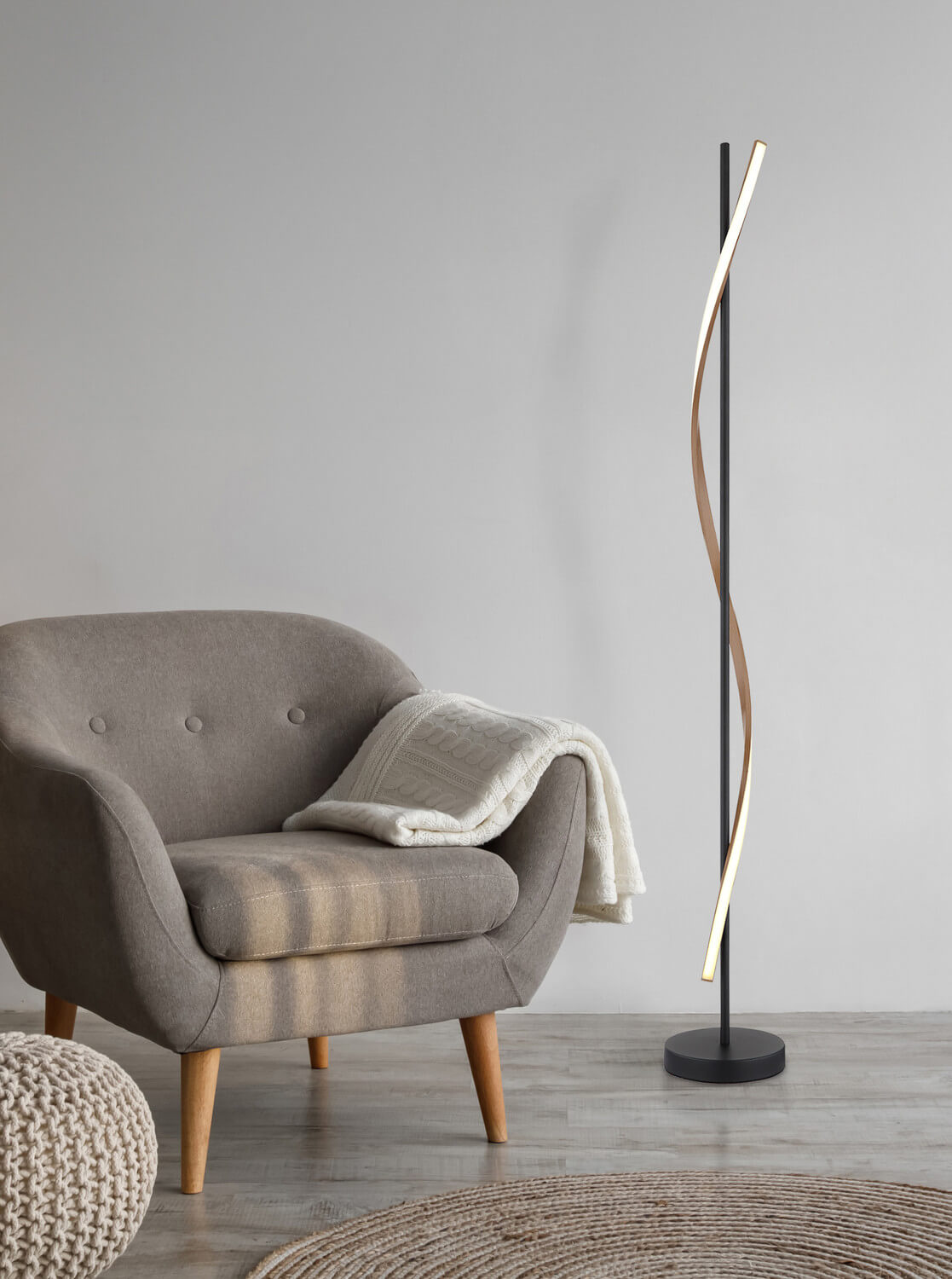 Mise en ambiance du lampadaire près d'un fauteuil et d'un tapis rond.