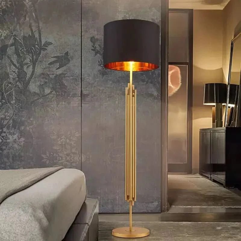 Lampadaire doré allumé dans une chambre, près d'un lit et papier peint