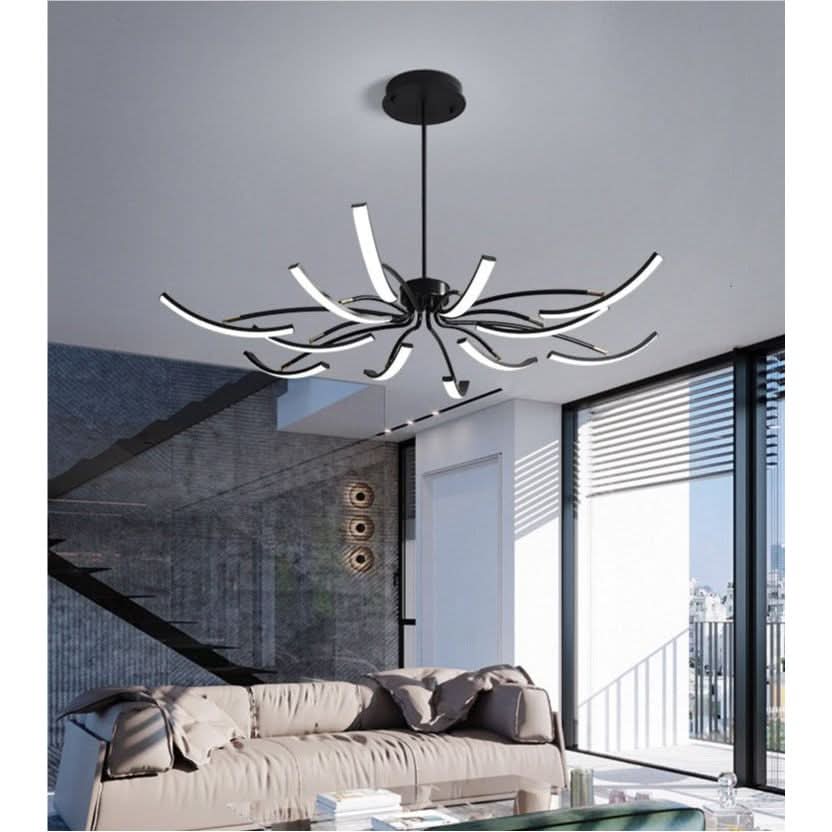 Luminaire suspendu aux bras fins éclairés, installé dans un salon contemporain clair.