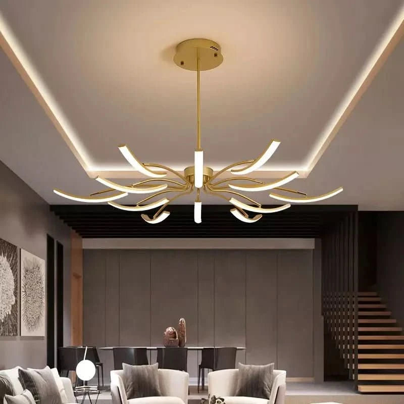 Vue de face du luminaire doré suspendu dans un salon haut de plafond éclairé.
