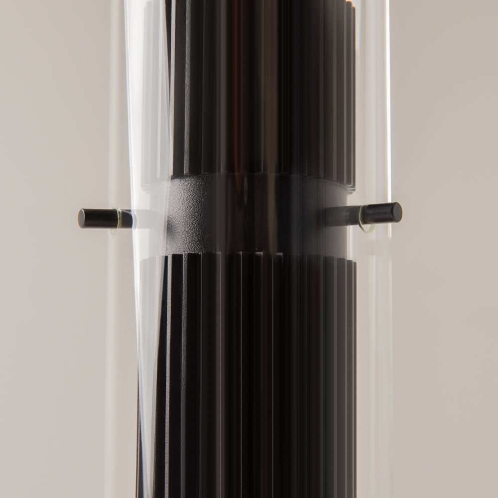 Détail rapproché du cylindre noir strié et de la fixation sur verre transparent.