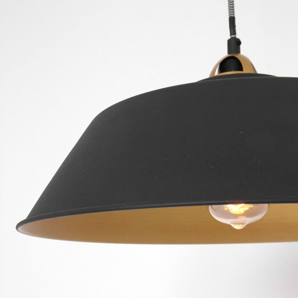 Détail de la douille dorée et du bord de l'abat-jour noir mat