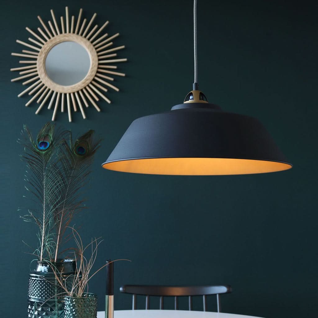 Lustre noir et doré au-dessus d'une table à manger