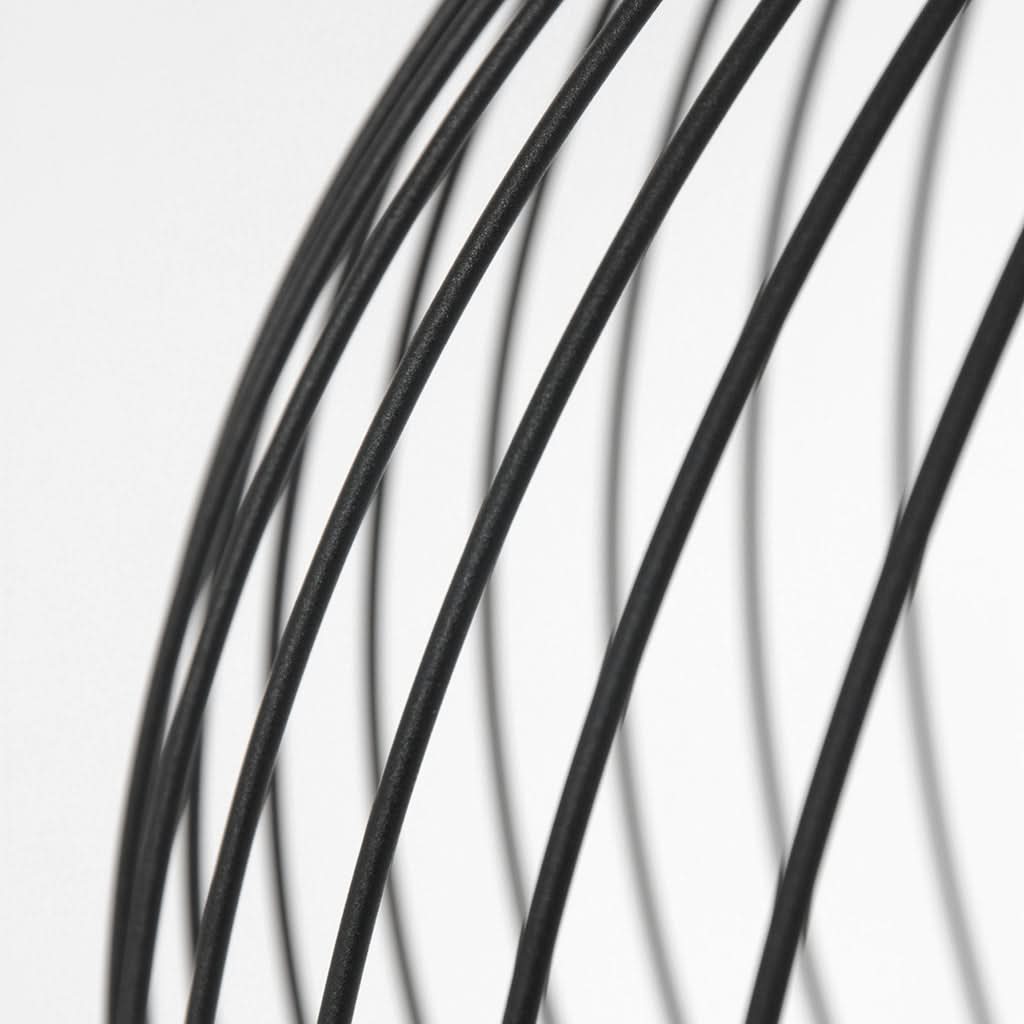 Gros plan sur les tiges métalliques noires courbées de la cage ajourée.