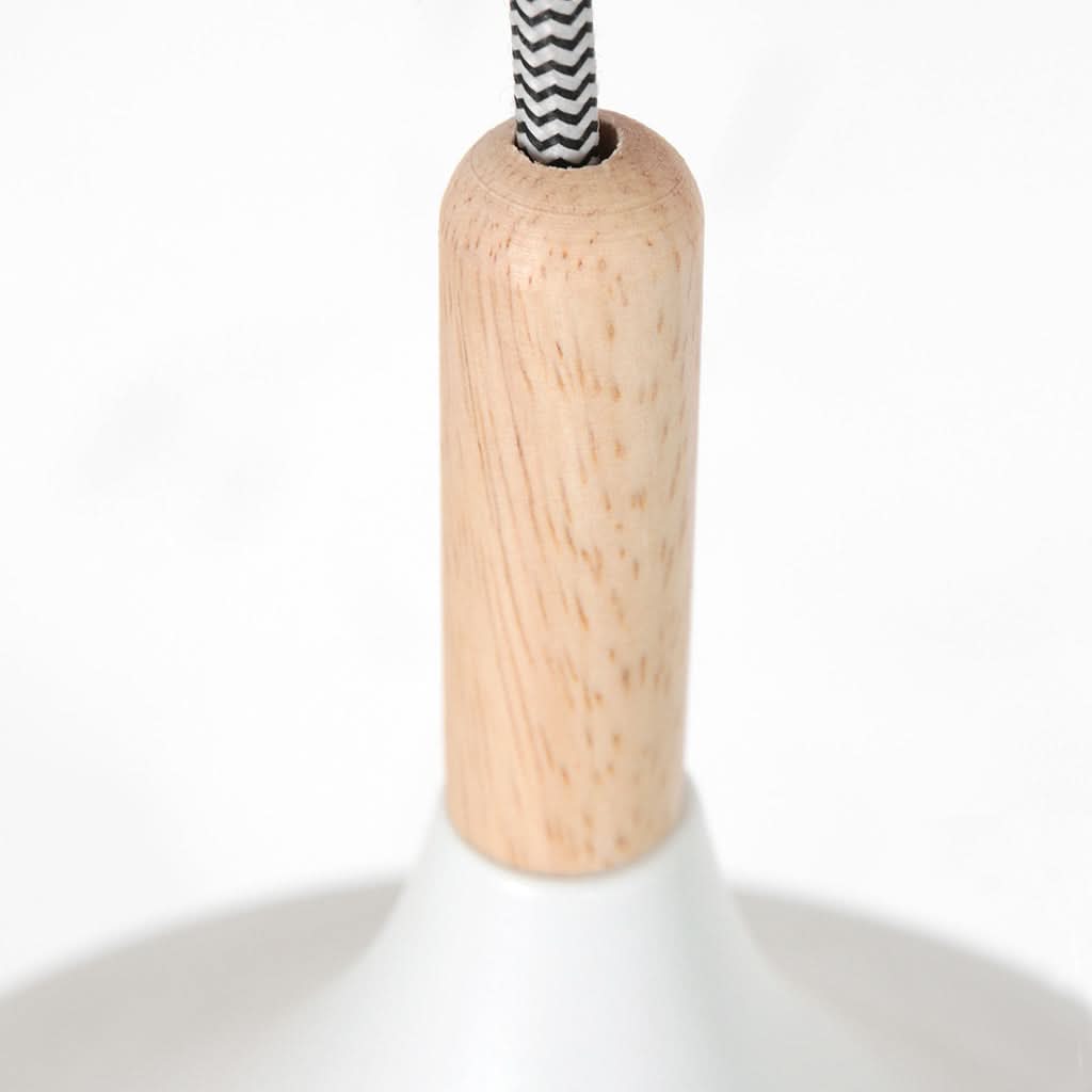 Détail du connecteur en bois clair et du cordon tressé à chevrons noirs et blancs.