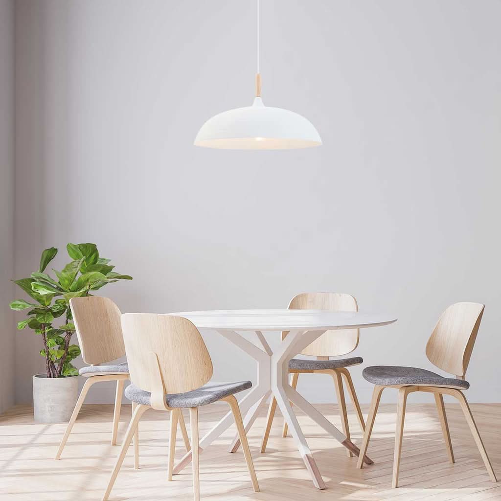 Mise en ambiance au-dessus d'une table ronde entourée de chaises en bois clair