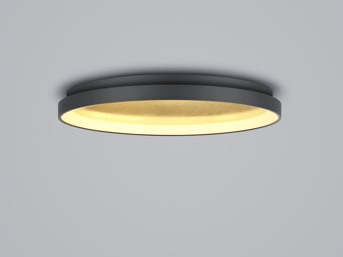 Vue de profil du luminaire noir éclairé, diffuseur doré en dessous
