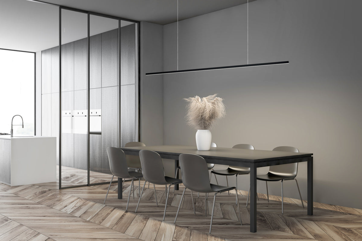 Mise en ambiance du luminaire suspendu au-dessus d'une table à manger dans une cuisine moderne.