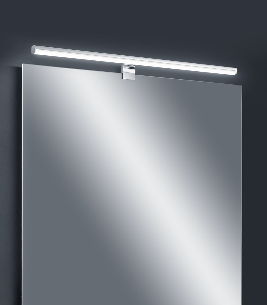 Vue de face de l'applique chromée allumée au-dessus d'un miroir de salle de bain