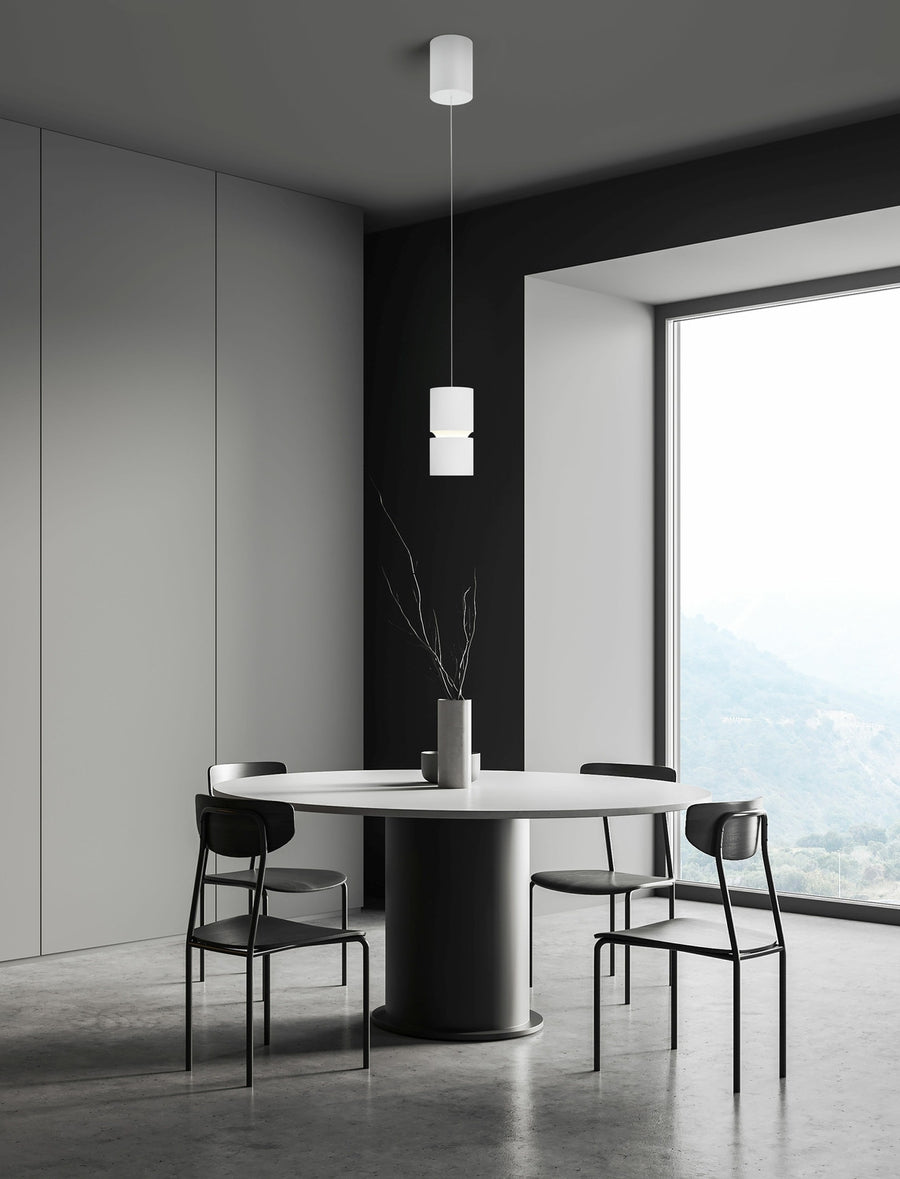 Suspension blanche installée au-dessus d'une table ronde dans un intérieur minimaliste.