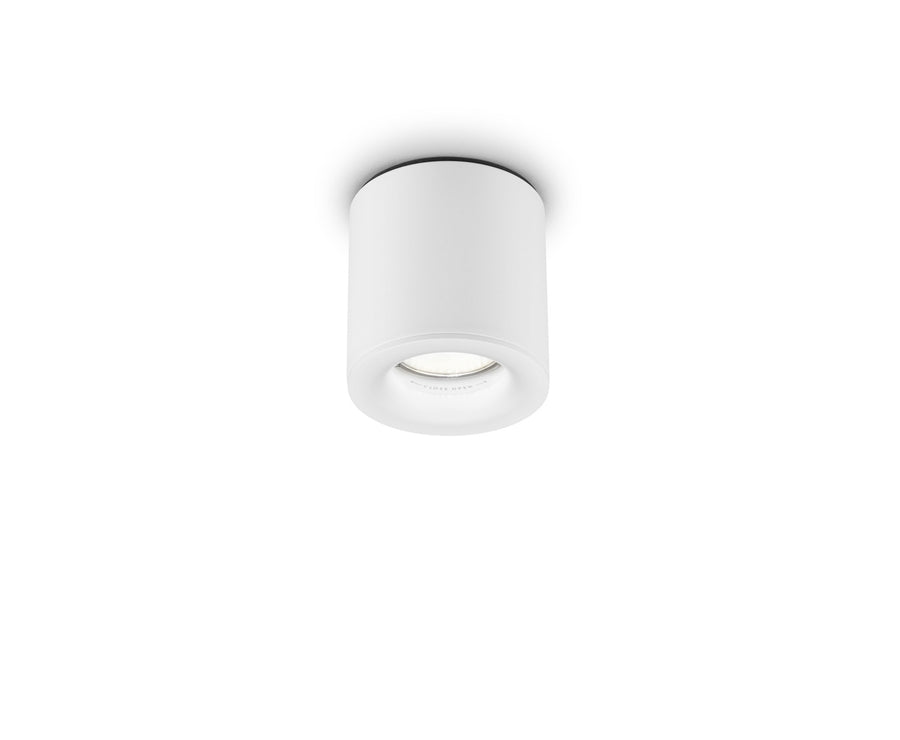 Vue de trois quarts du spot cylindrique blanc orientable, posé en saillie, fond neutre