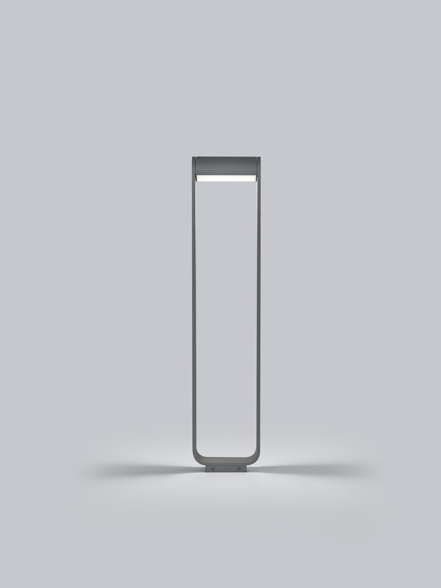 Vue frontale du luminaire dressé, montrant ses proportions hautes et fines