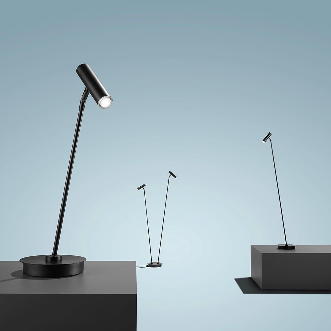 Mise en ambiance de trois lampes noires posées sur des socles gris