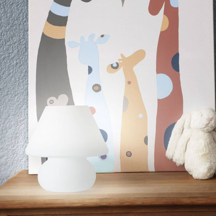 Lampe allumée posée sur une commode dans une chambre d'enfant