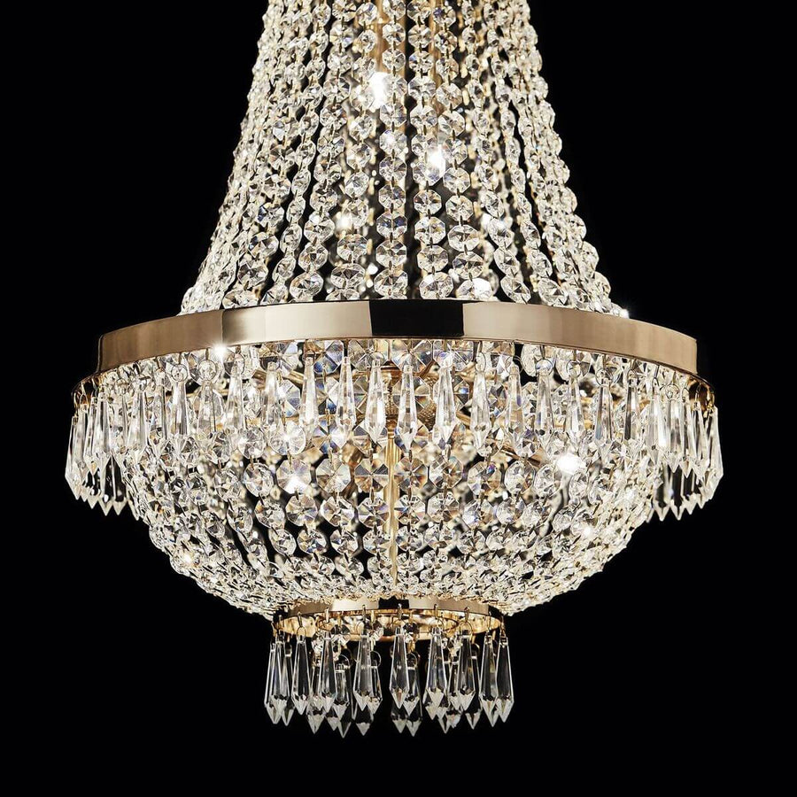 Gros plan sur le cercle doré et les pendentifs en cristal illuminés sur fond noir