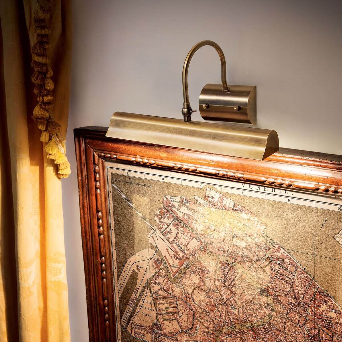 Applique rétro éclairant une carte ancienne encadrée dans une ambiance chaleureuse