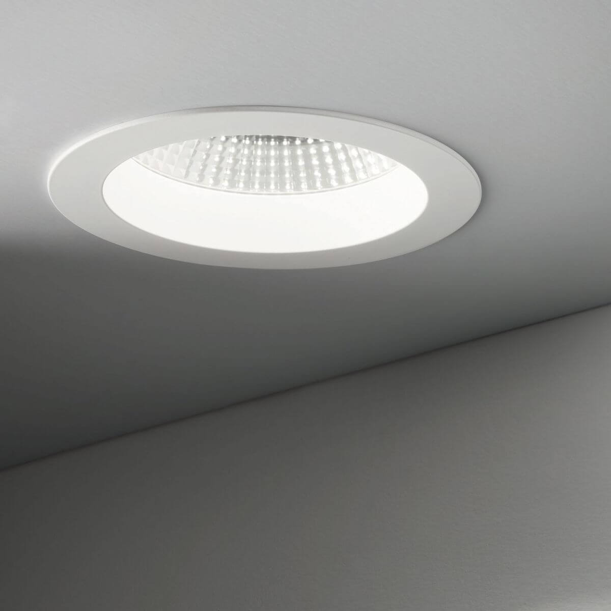 Spot blanc encastré dans un plafond gris, éclairé, en situation.