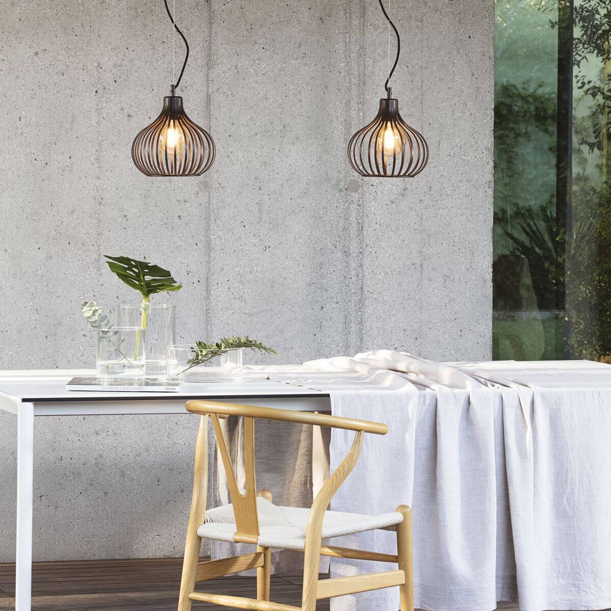 Mise en ambiance au-dessus d'une table, mur béton et deux suspensions allumées