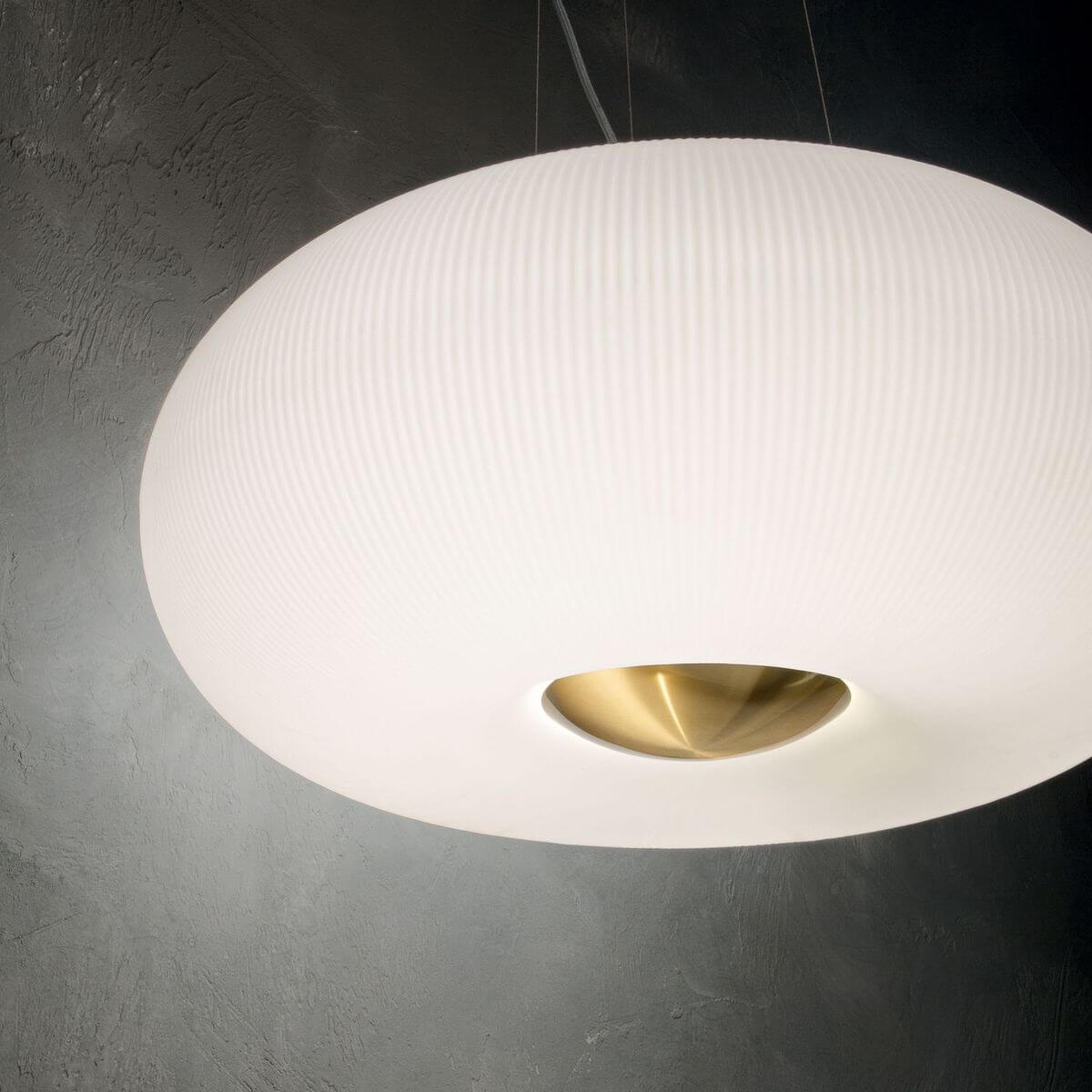 Vue en ambiance sombre du luminaire allumé, diffusant une lumière chaude.