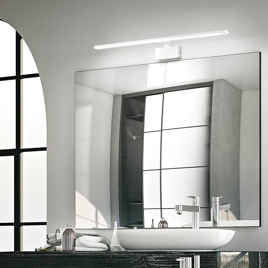 Applique murale allumée au-dessus d'un miroir, reflet dans salle de bain moderne.