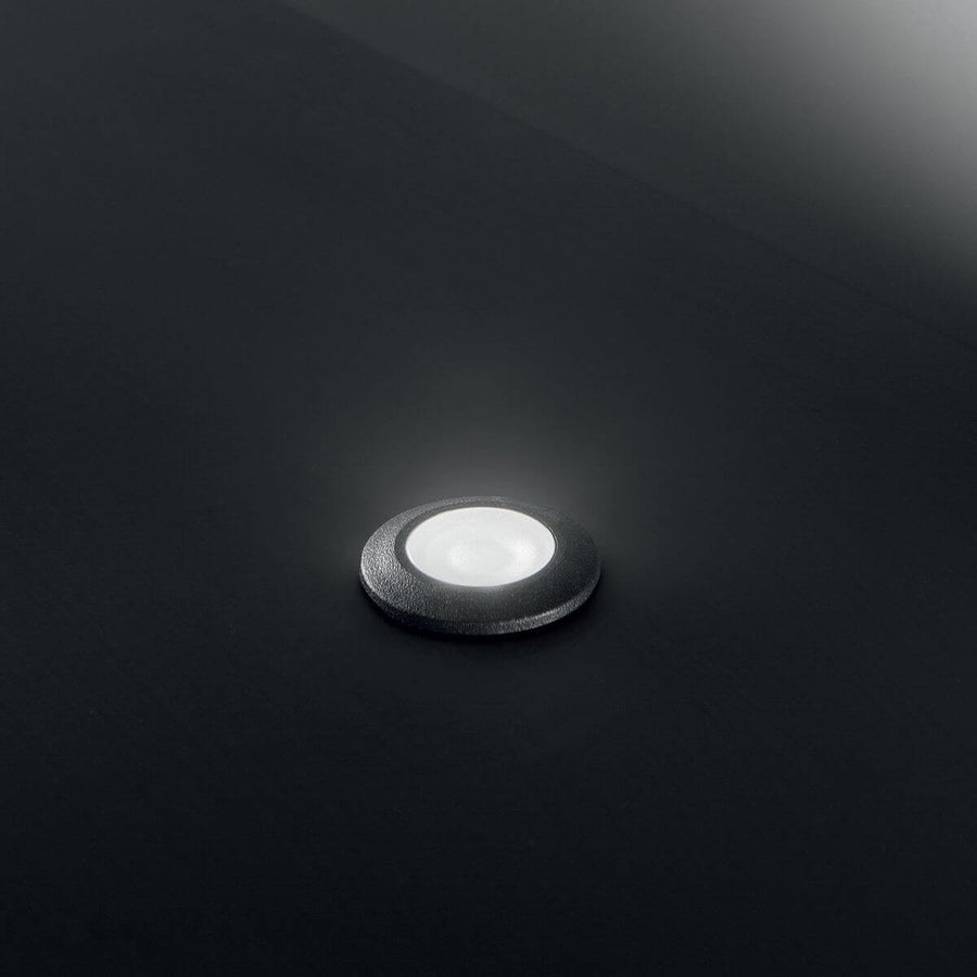 Luminaire extérieur allumé sur fond sombre, halo lumineux blanc