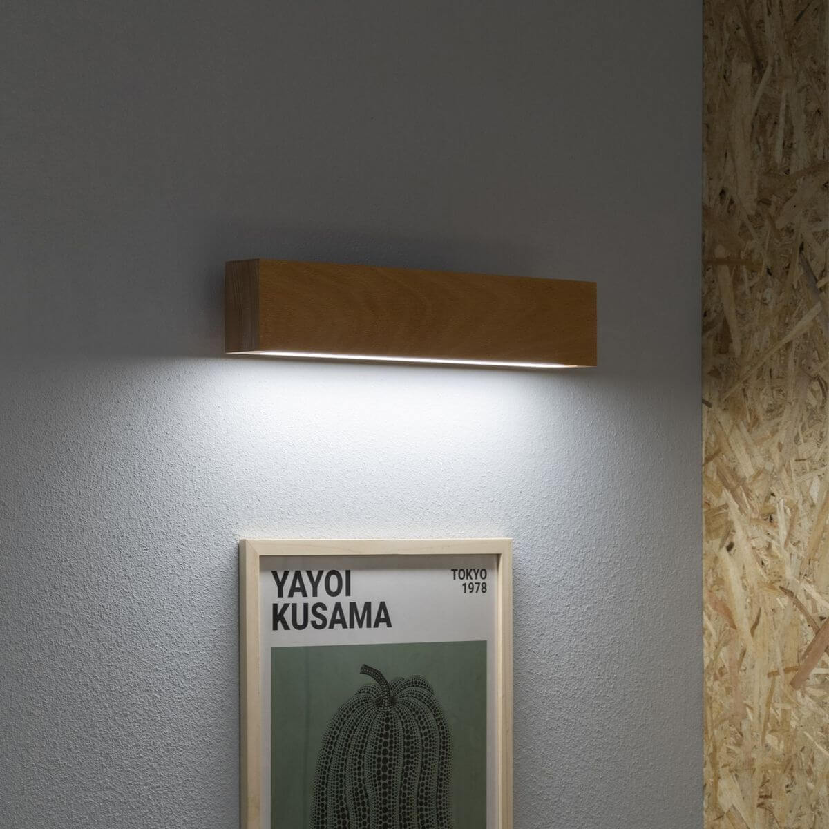 Mise en ambiance au-dessus d'une affiche encadrée sur mur gris