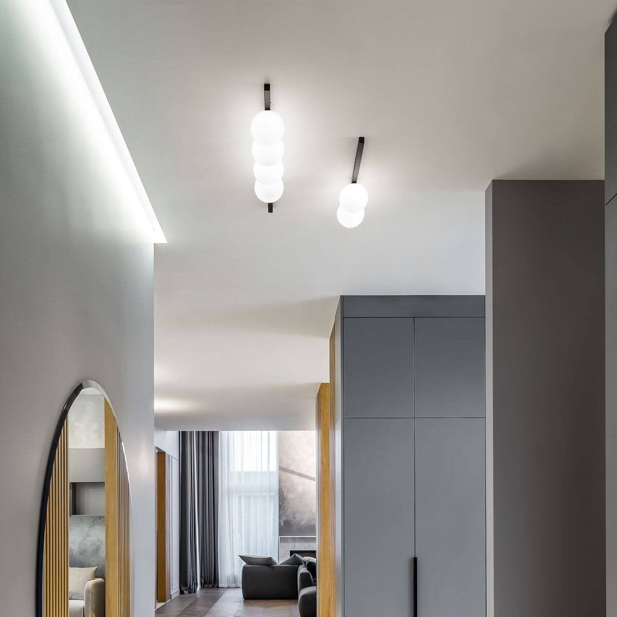 Mise en ambiance dans un couloir moderne, deux plafonniers semblables fixés au plafond.