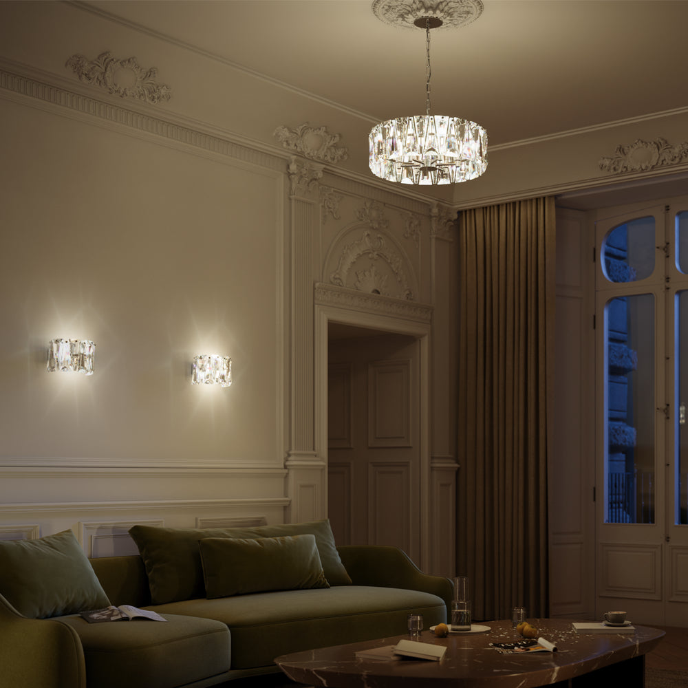 Intérieur haussmannien : deux appliques murales allumées éclairant un salon au canapé vert