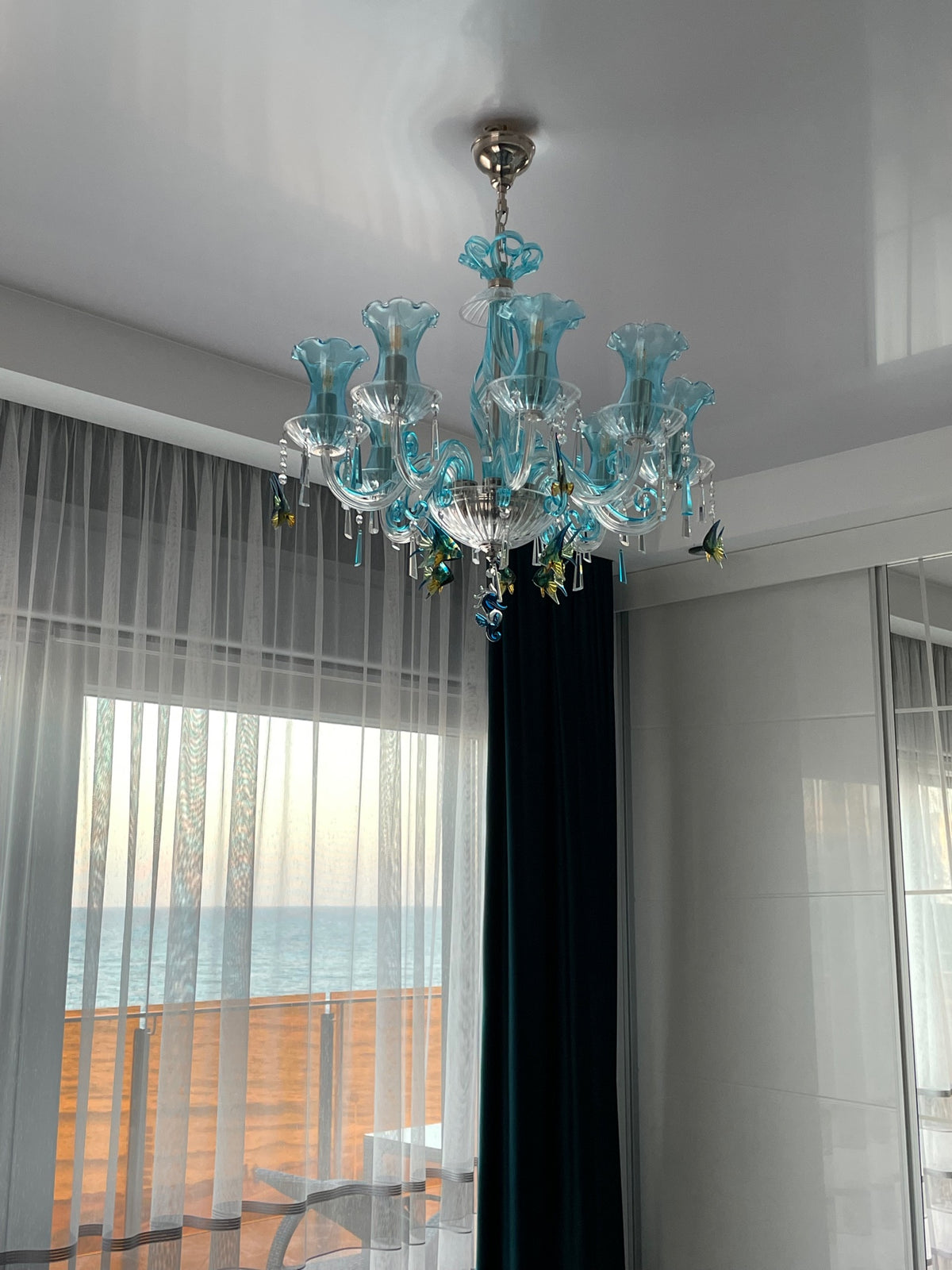 Vue du lustre près d'une fenêtre donnant sur la mer et le balcon