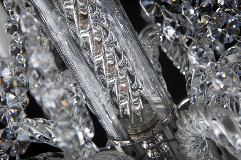 Macro du fût central en verre torsadé et des chaînes de cristal du luminaire.