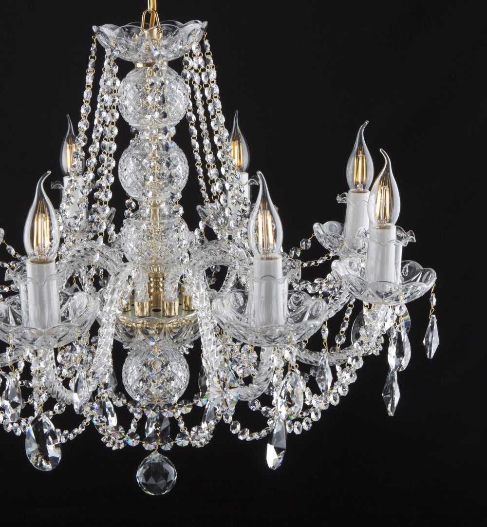 Gros plan du lustre en cristal montrant le cristal taillé et les bras lumineux